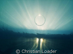 bubble ring and sunburst - under the jetty at the Four Se... by Christian Loader 